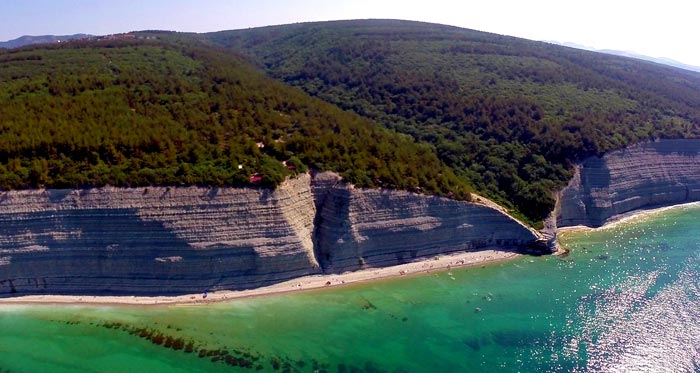 Кемпинг находится в лесу на вершине скалы, над пляжем "Сосновка"