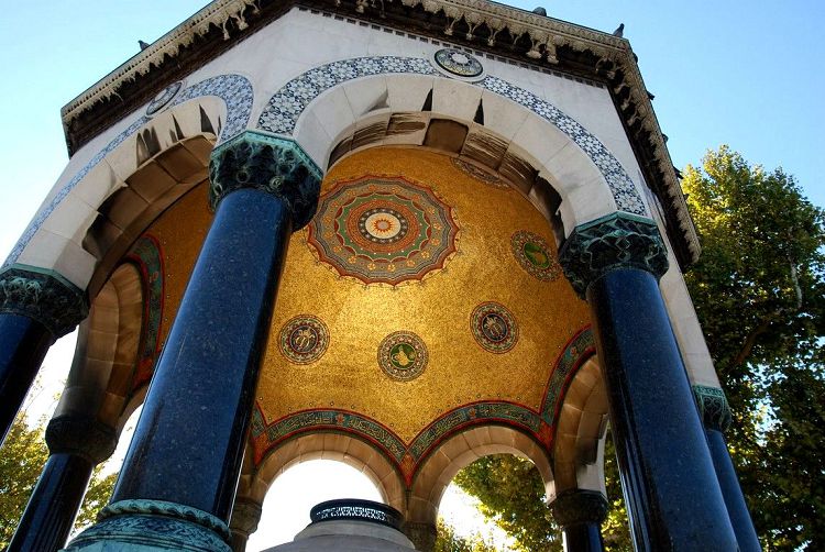 Среди мозаичного золота потолка фонтана находятся вензеля венценосных правителей